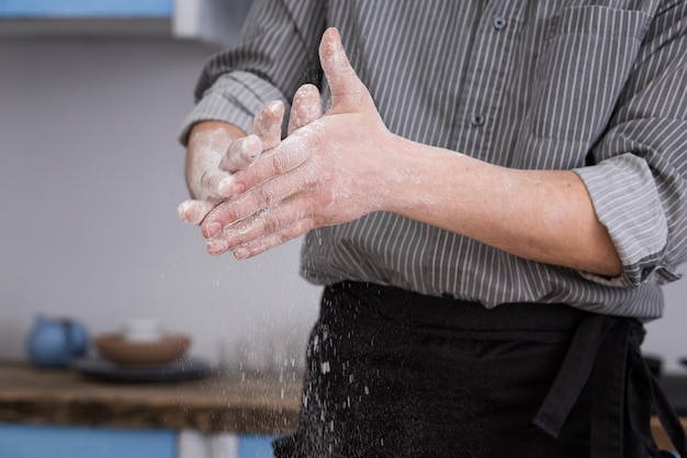 Um homem assa farinha de pão nas mãos