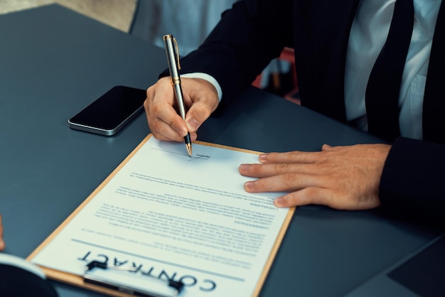 Um homem assinando um documento com uma caneta