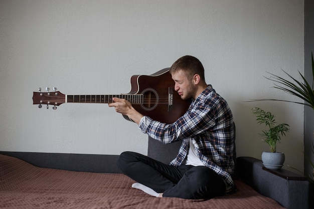 Um homem atira em sua guitarra como uma arma