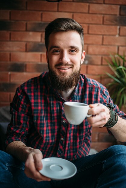 Um homem barbudo bebe café no café. lazer masculino em bar