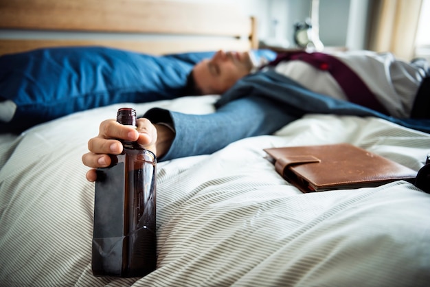 Um homem bêbado desmaiar na cama