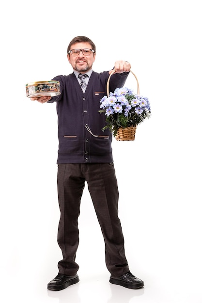 Um homem bonito de terno e óculos com doces e flores fundo branco