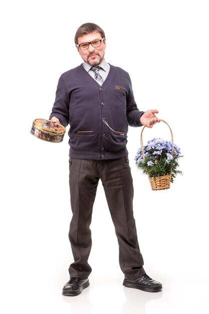 Um homem bonito de terno e óculos com doces e flores Fundo branco