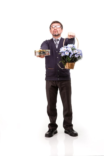 Um homem bonito de terno e óculos com doces e flores Fundo branco