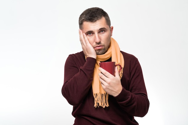 Um homem bonito toca a boca com a mão com uma expressão de dor porque