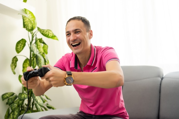 Foto um homem brinca com um joystick em casa em um fundo preto