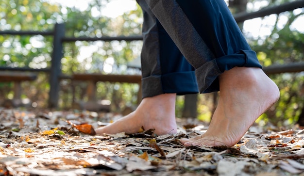 Um homem caminhando descalço por uma estrada arborizada Conceito de estilo de vida saudável