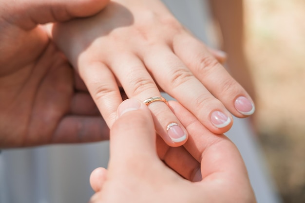 Um homem coloca um anel de casamento no dedo de uma mulher Closeup