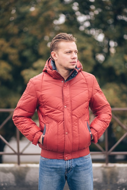 Um homem com as mãos nos bolsos em uma jaqueta de inverno ao ar livre