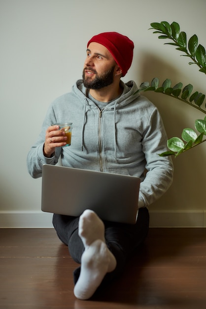 Um homem com barba trabalhando em seu laptop