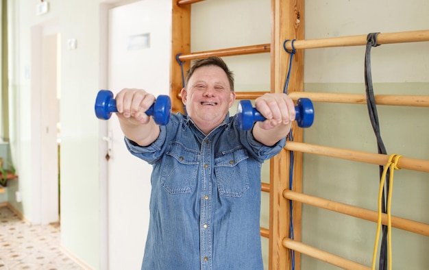 Um homem com síndrome de down pratica esportes com halteres nas mãos