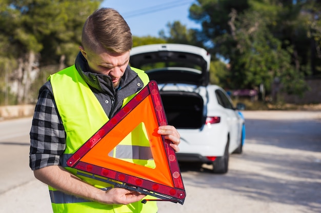 Foto um homem com um carro recebe uma placa de emergência