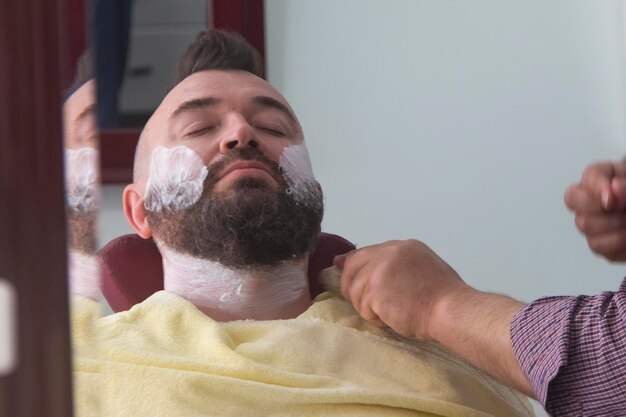 Um homem com um moicano e barba na barbearia