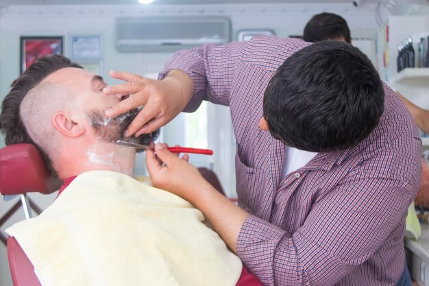 Um homem com um moicano e barba na barbearia