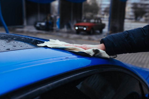 Um homem com um pano para secar o carro. conceito de lavagem de carro