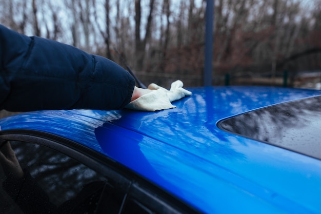 Um homem com um pano para secar o carro. conceito de lavagem de carro