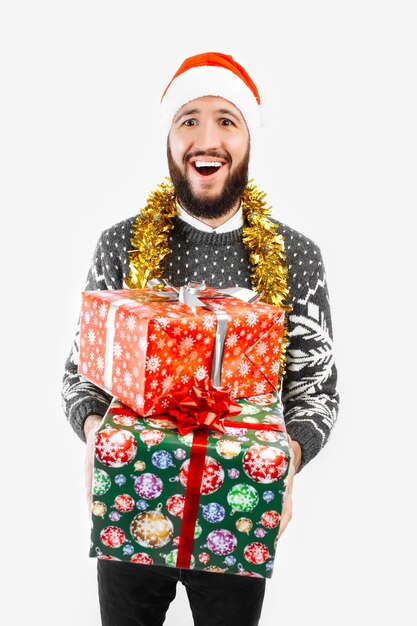 Um homem com um presente de Natal nas mãos no estúdio em um fundo branco