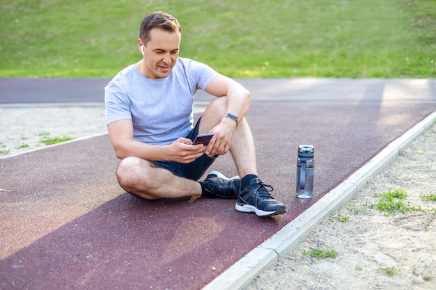 Um homem com um smartphone enquanto pratica esportes