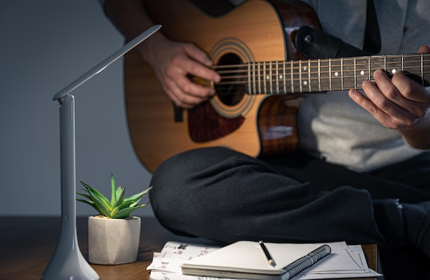 Um homem com um violão cria música toca à noite