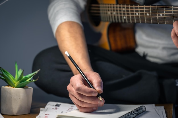 Um homem com um violão cria música toca à noite