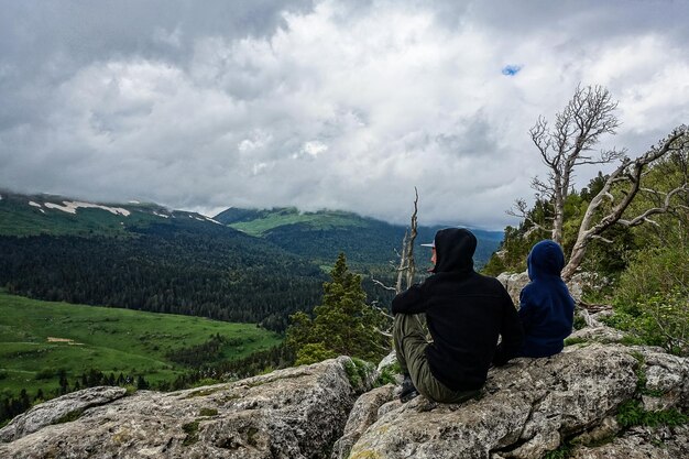 Um homem com uma criança no fundo dos prados alpinos do planalto LagoNaki na Adygea Rússia 2021