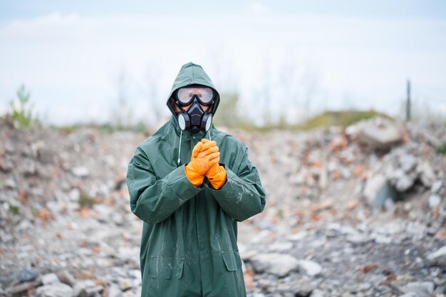 Um homem com uma máscara de proteção e roupas de proteção explora a zona de perigo Foco seletivo de catástrofe ecológica