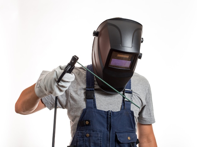 Um homem com uma máscara de soldagem, roupas robóticas e luvas, segurando um fio com um eletrodo de soldagem.