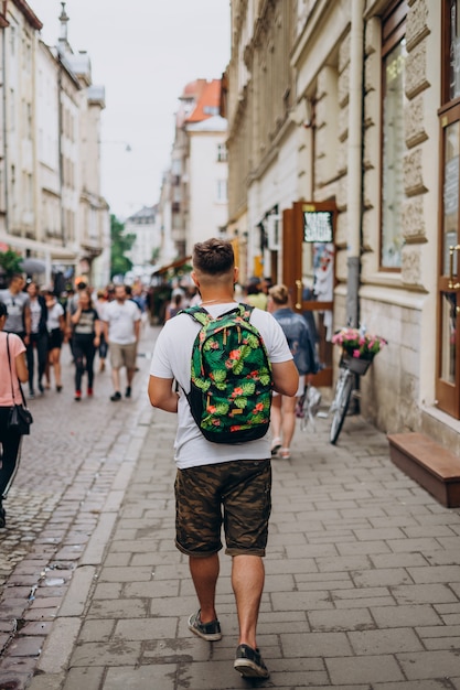 Um homem com uma mochila em um passeio pela cidade no verão.