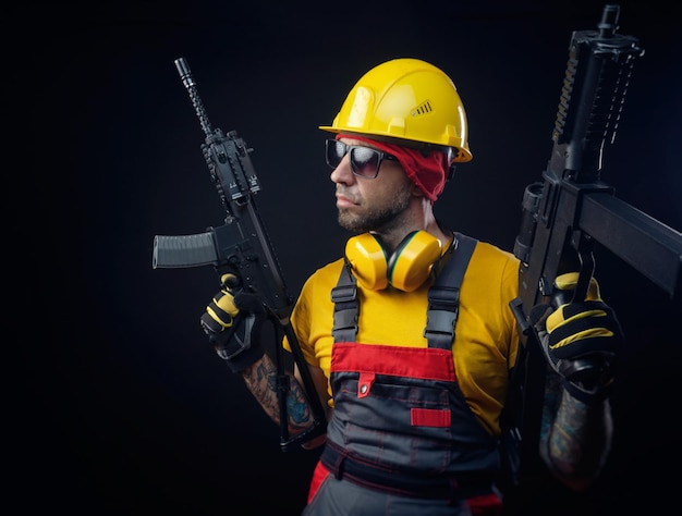 Um homem com uniforme de trabalhador da construção civil usando um capacete com uma arma de airsoft nas mãos