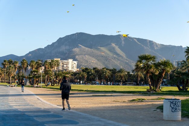 Um homem corre por um caminho na frente de uma grande montanha