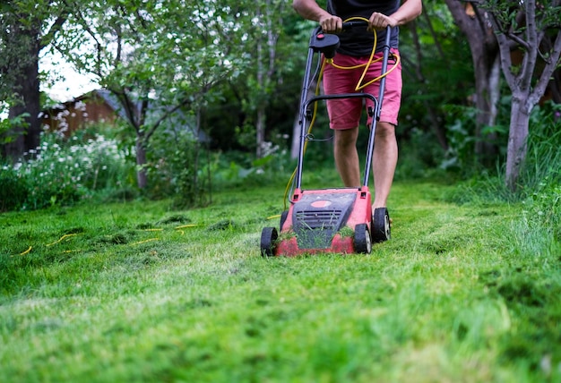 Um homem cortando a grama com um cortador de grama