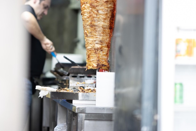 Um homem cozinha shawarma carne é frito em uma válvula