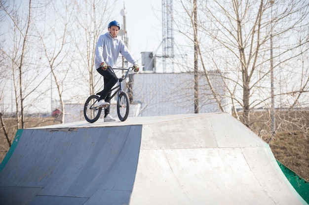 Um homem de bicicleta no topo dos half pipes