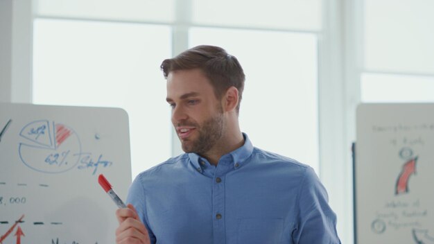 Foto um homem de camisa azul está escrevendo em um quadro branco com a palavra eu sou um.