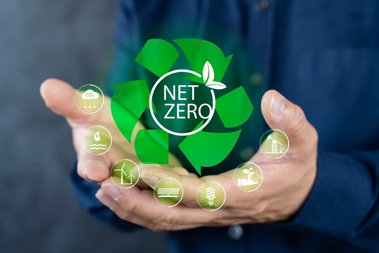 Um homem de camisa azul segura um símbolo de reciclagem verde com as palavras "net zero". O símbolo de recycling tem uma planta nele sugerindo que a reciclar