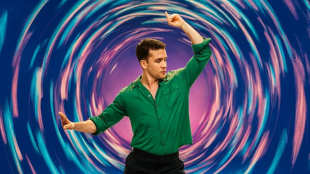 um homem de camisa verde está dançando na frente de um padrão em espiral colorido