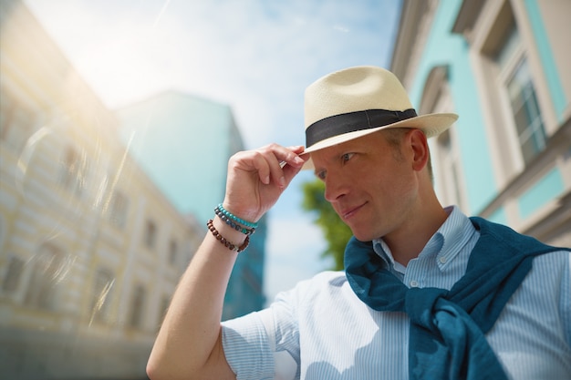 um homem de chapéu está andando pela cidade