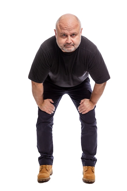 Um homem de meia idade careca sério está de pé. isolado sobre o branco vertical.