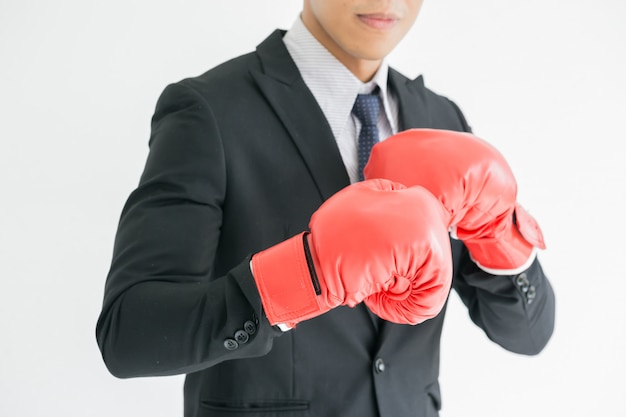 Um homem de negócios durão está usando luvas de boxe