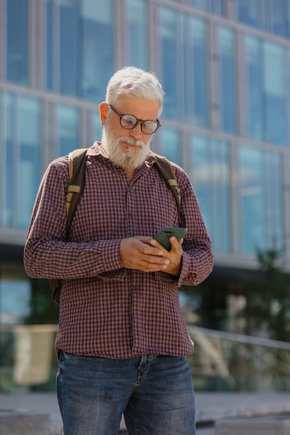 Um homem de negócios sênior usando uma camisa e um laptop está fazendo carreira em uma grande empresa