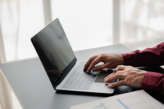 Um homem de negócios trabalhando em uma sala privada Ele está digitando no teclado de um laptop Ele usa um mensageiro para conversar com um parceiro Conceito de uso da tecnologia na comunicação