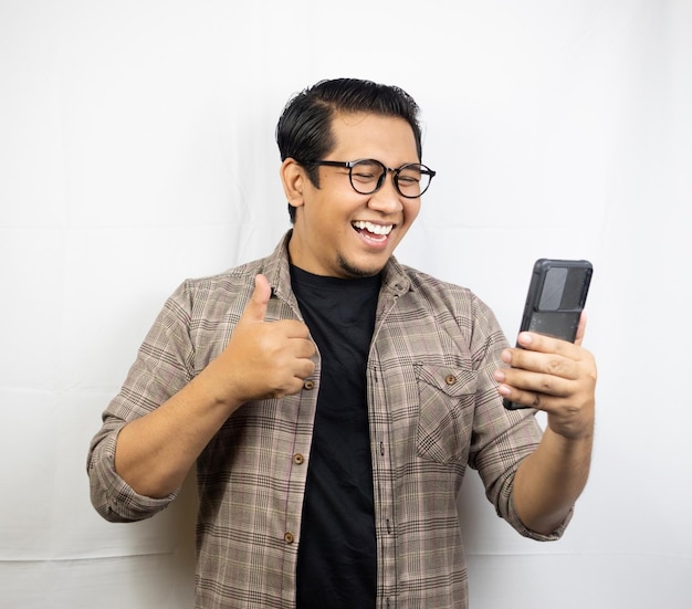 um homem de óculos está sorrindo e segurando um telefone.
