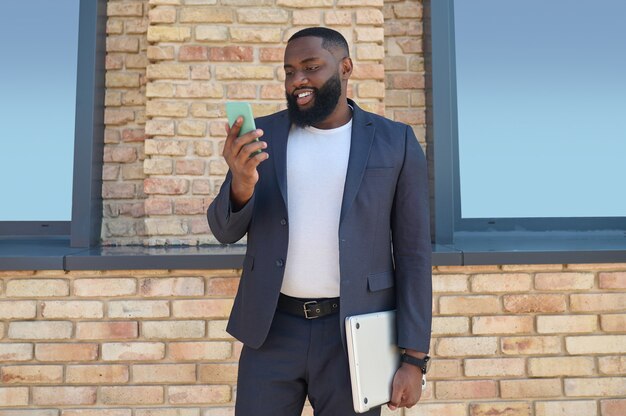 Um homem de pele escura com um telefone na mão