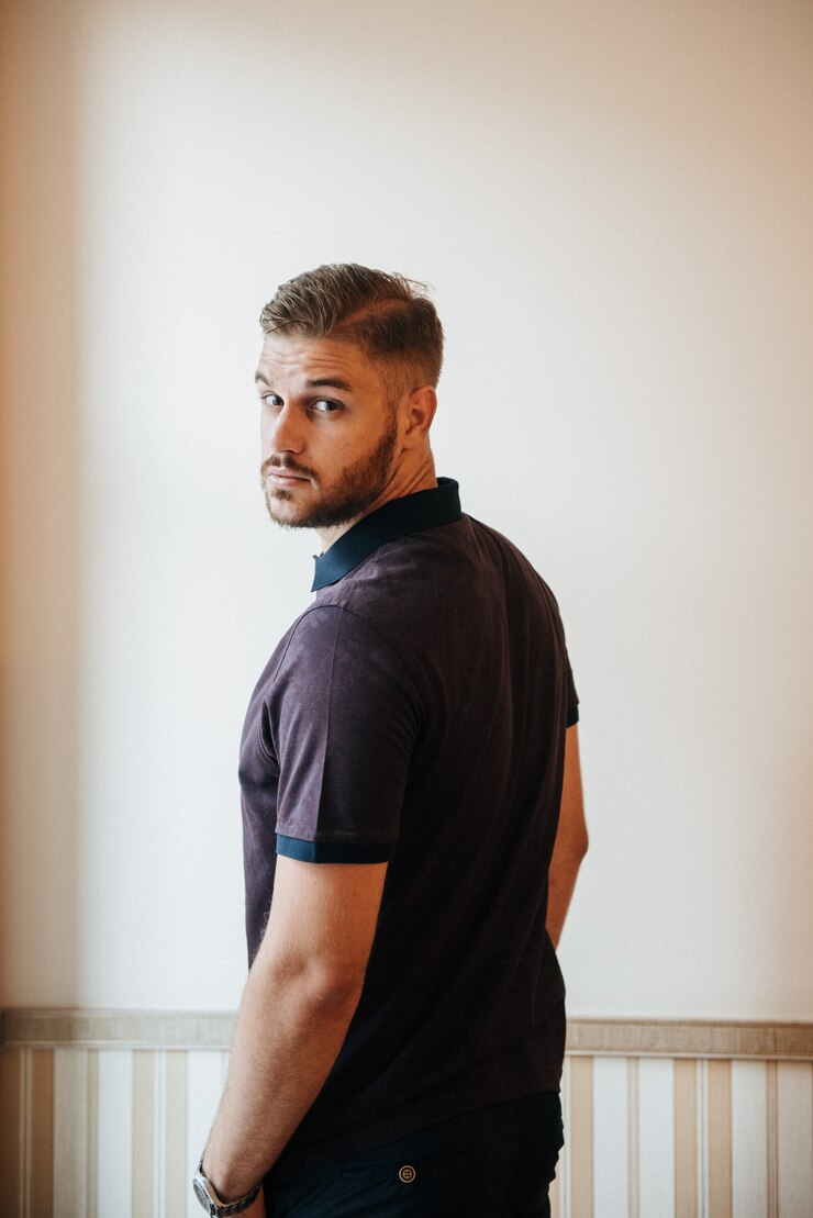 Foto um homem de pólo roxo e posando para anunciar roupas masculinas. tiro para loja de roupas masculinas
