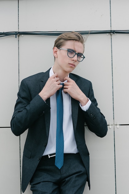 Foto um homem de terno cinza e gravata azul está posando.