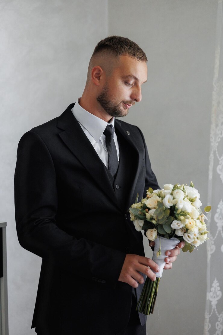 Foto um homem de terno e gravata segurando um buquê de flores