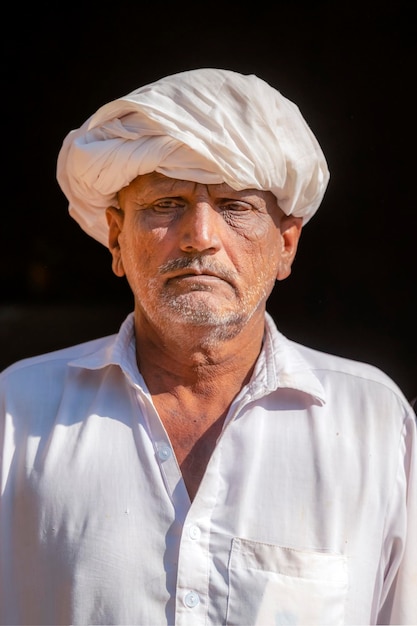 Um homem de turbante está em frente a um prédio.