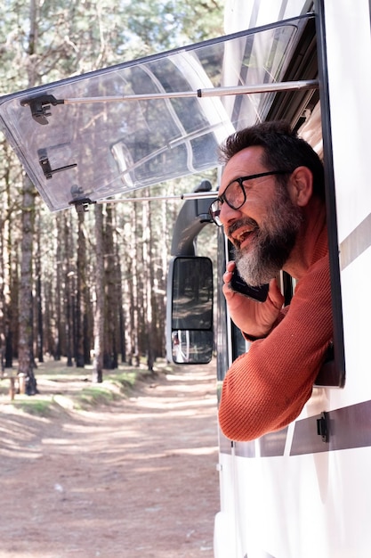 Um homem desfrutando da vista do lado de fora da janela de uma caravana de camper desfrutar de vanlife e veículo de viagem alternativo férias férias liberdade estilo de vida nômade pessoas fulltimers estacionamento gratuito van