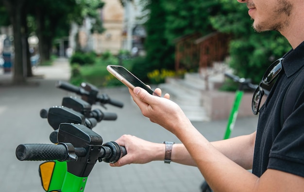 Um homem destrava uma escooter com seu telefone celular