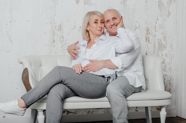 um homem e sua esposa em camisas brancas no sofá